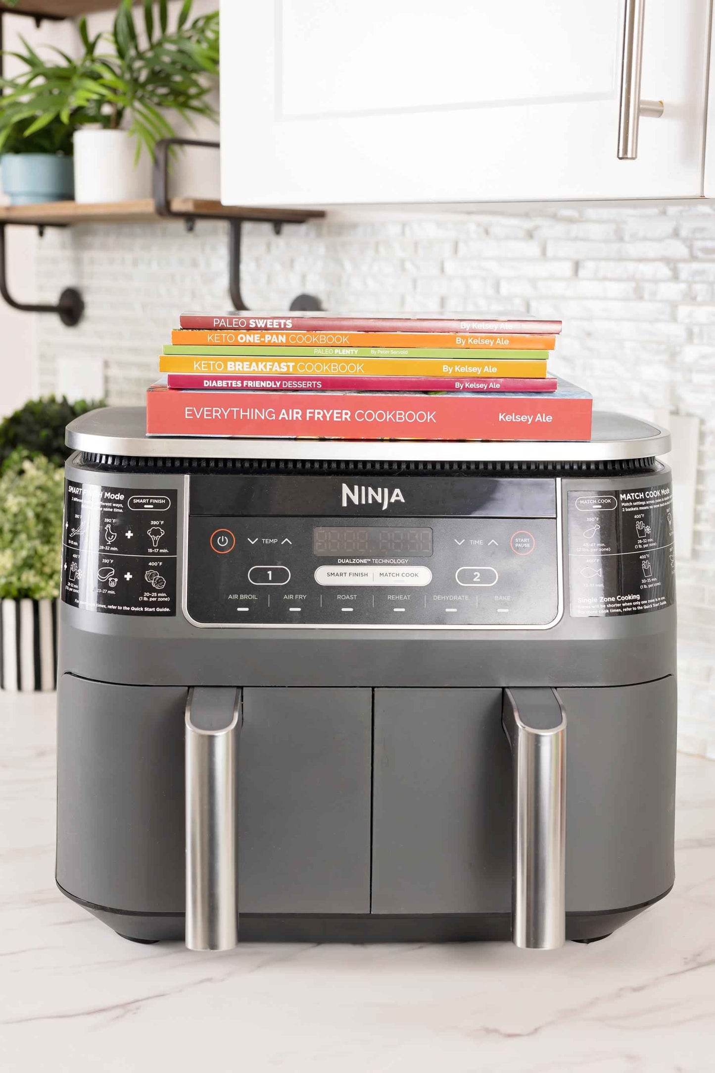 An air fryer with cookbooks on it.