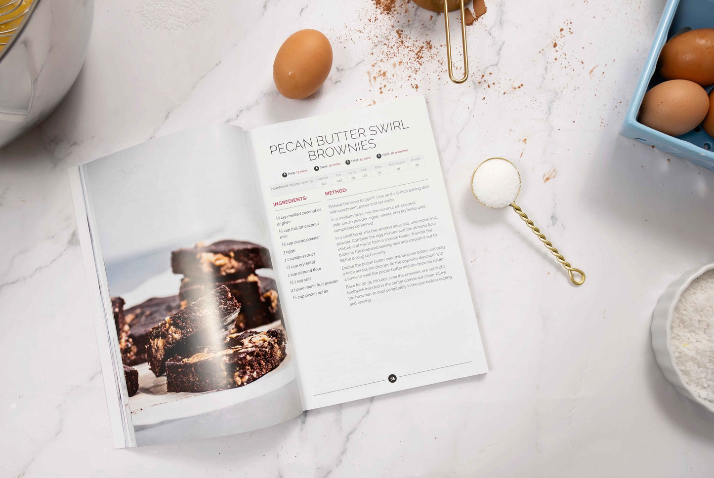 The Diabetes Desserts cookbook is laid on the kitchen counter open to the Pecan Butter Swirl Brownies page