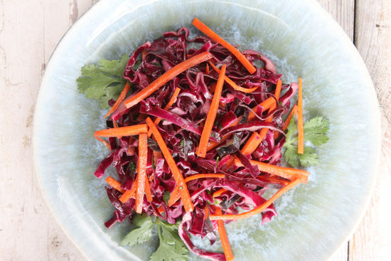 A plate of Spicy Cabbage Slaw placed on a marble plain surface.