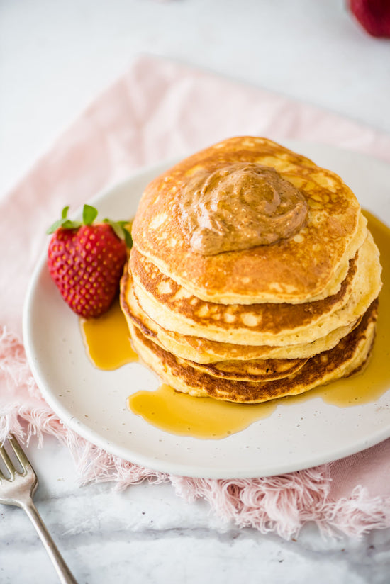 A plate of Almond Flour Pancakes on a plain white surface.