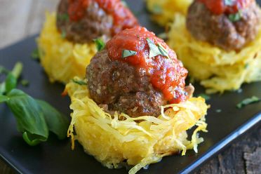 A grey tray of meatballs in spaghetti squash nests.
