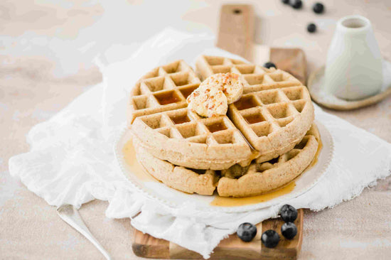 A wooden board of Almond Flour Waffles with blueberries.