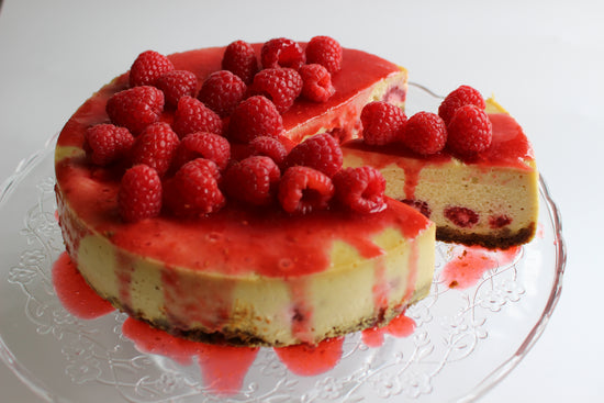 A white chocolate cheesecake with raspberries