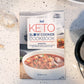 Keto slow cookbook placed on a marble surface. Garlic and cookware can also be seen in the scene