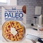 The Paleo Breakfast Recipes Cookbook stands on a kitchen counter next to a measuring cup and a grater.