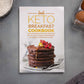 Keto breakfast cookbook  placed on a grey surface, surrounded by eggs and sea salt.