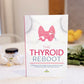  The Thyroid Reboot book stands on a plain marble surface. Bottles of avocado oil, bulbs of garlic, and vegetables can be seen in the background.